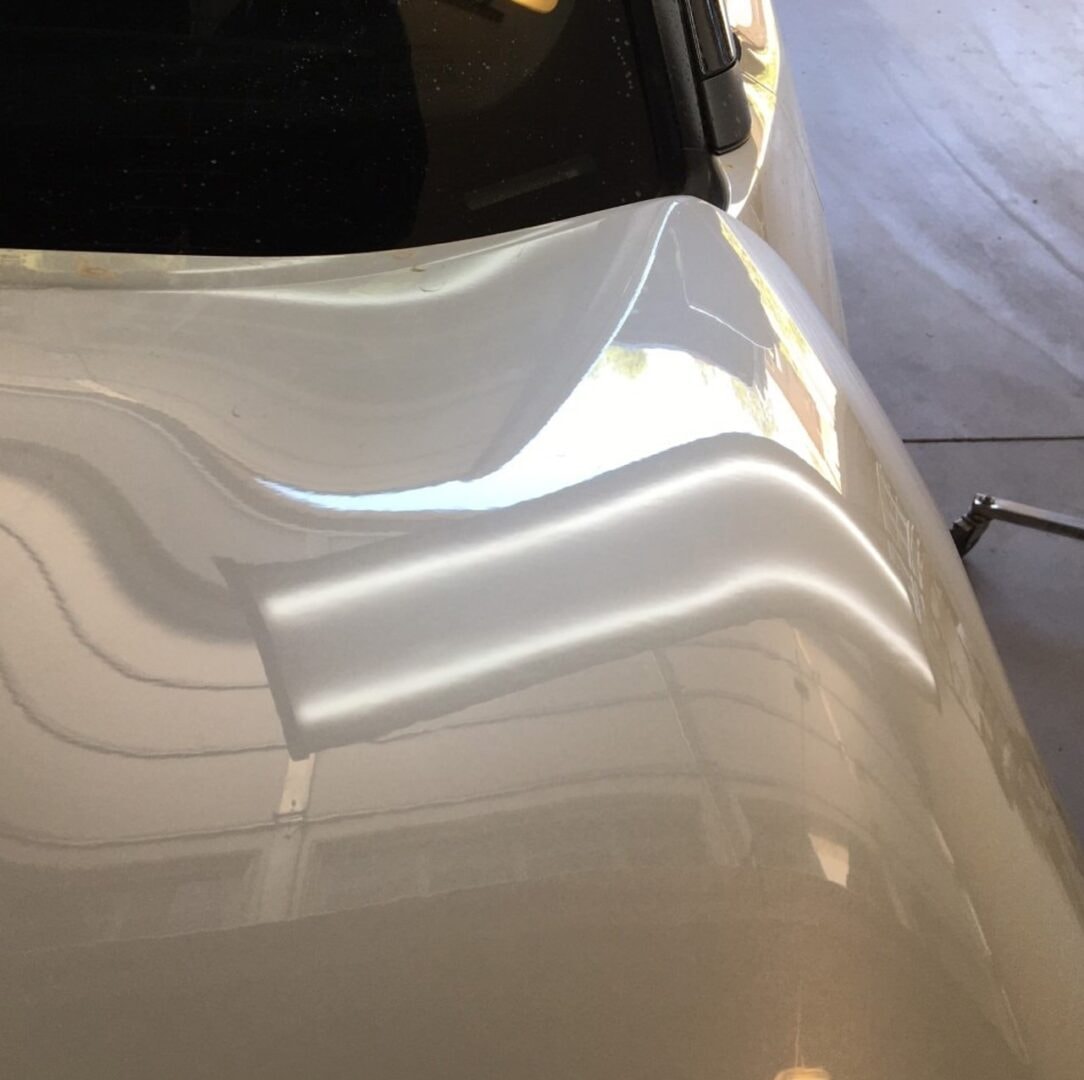 White car panel with smooth finish after paintless dent repair