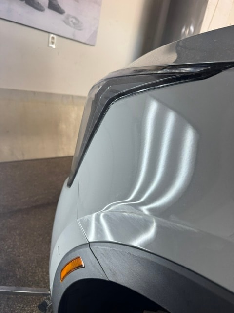 Silver truck fender with crease dent before paintless dent repair