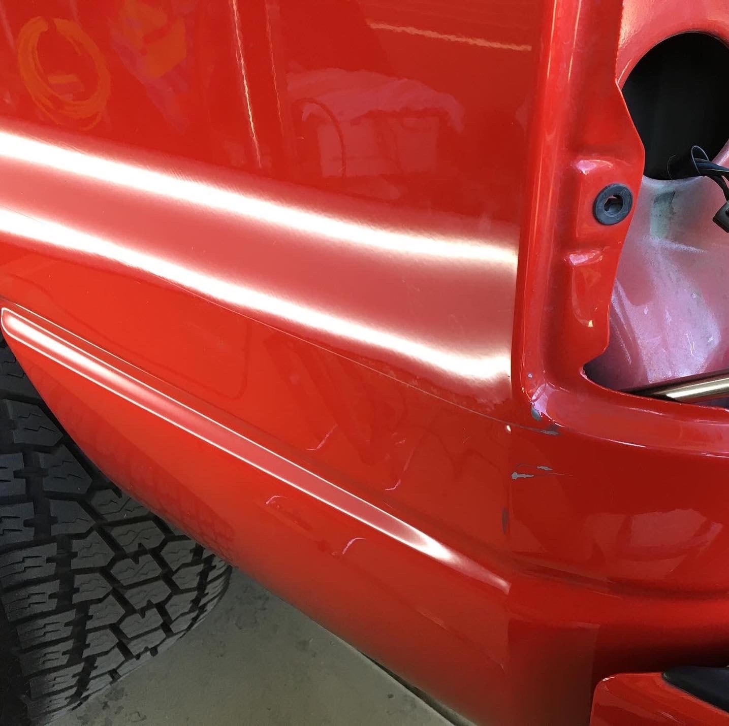 Red truck door panel smooth and restored after paintless dent repair