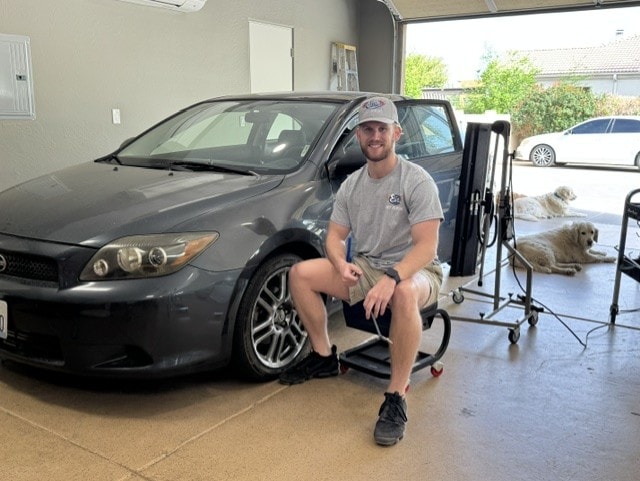 Technician posing with gray Scion after completing dent repair